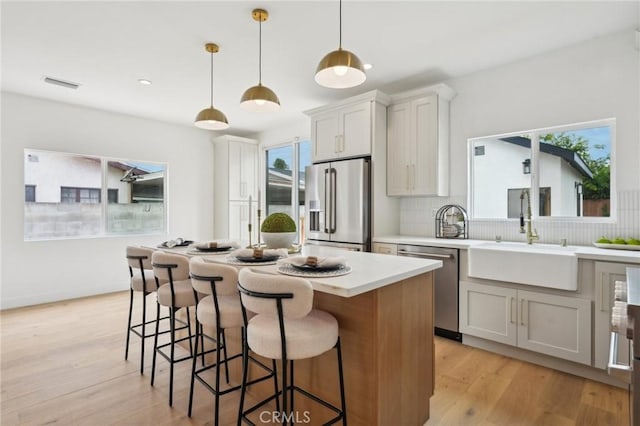 5449 S Victoria Ave, Los Angeles, CA 90043 - kitchen with tasteful backsplash, a sink, visible vents, stainless steel appliances, and a kitchen island