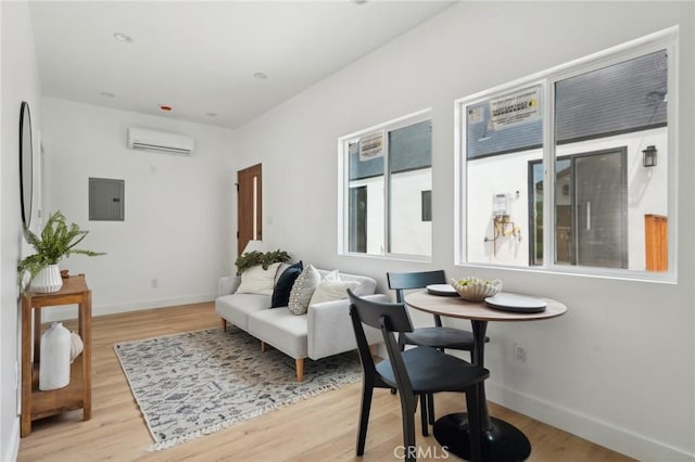 5449 S Victoria Ave, Los Angeles, CA 90043 - living area with electric panel, wood finished floors, a wall mounted AC, and baseboards