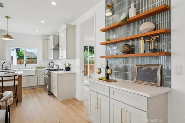 5449 S Victoria Ave, Los Angeles, CA 90043 - bar with a sink, decorative backsplash, a healthy amount of sunlight, light wood-type flooring, and stainless steel stove
