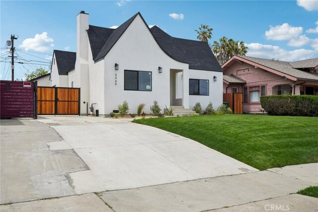 5449 S Victoria Ave, Los Angeles, CA 90043 - view of front of home with a front lawn, a shingled roof, stucco siding, and a gate