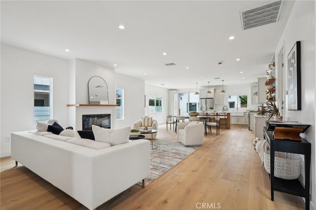5449 S Victoria Ave, Los Angeles, CA 90043 - living room with a glass covered fireplace, visible vents, light wood-style flooring, and recessed lighting
