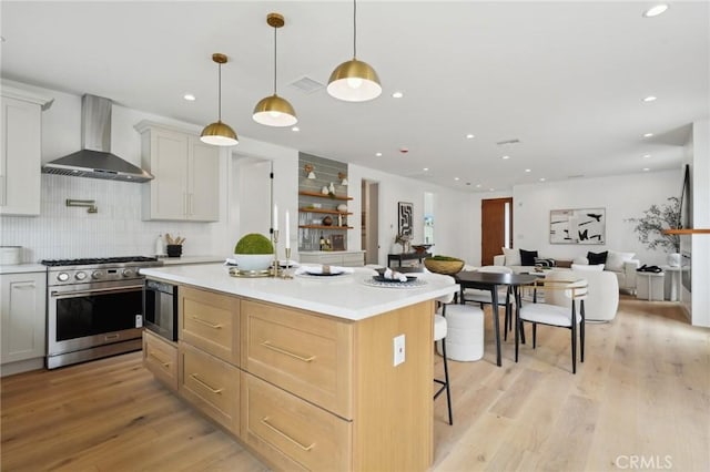 5449 S Victoria Ave, Los Angeles, CA 90043 - kitchen with wall chimney range hood, light wood-type flooring, light countertops, and stainless steel stove
