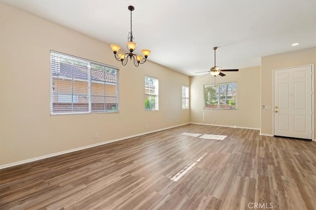 unfurnished room with light wood-type flooring, ceiling fan with notable chandelier, and baseboards