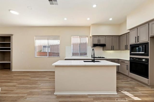 kitchen with black appliances, a sink, visible vents, and gray cabinets