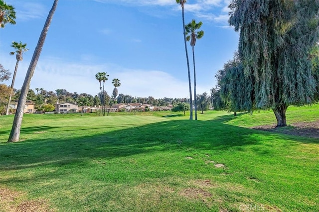 view of property's community with a residential view, a yard, and view of golf course