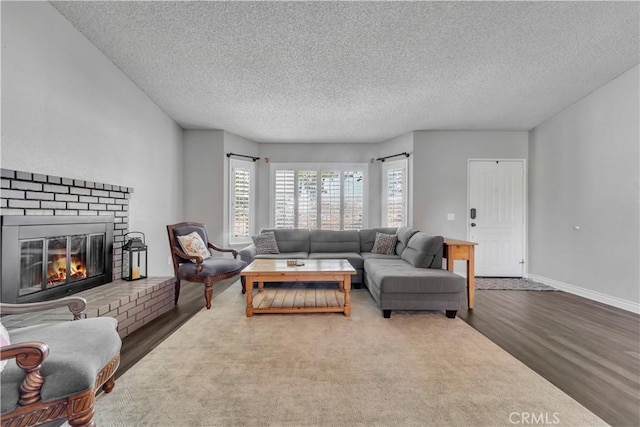 37025 96th St E, Littlerock, CA 93543 - living room featuring a fireplace, a textured ceiling, wood finished floors, and baseboards