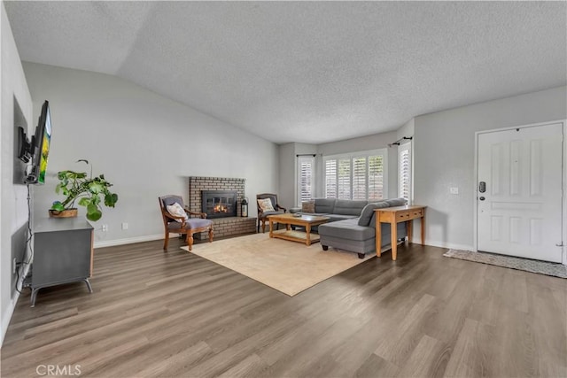37025 96th St E, Littlerock, CA 93543 - living room with wood finished floors, a fireplace, baseboards, a textured ceiling, and lofted ceiling