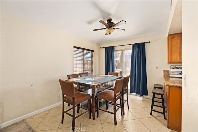 dining area with baseboards, light tile patterned floors, and ceiling fan