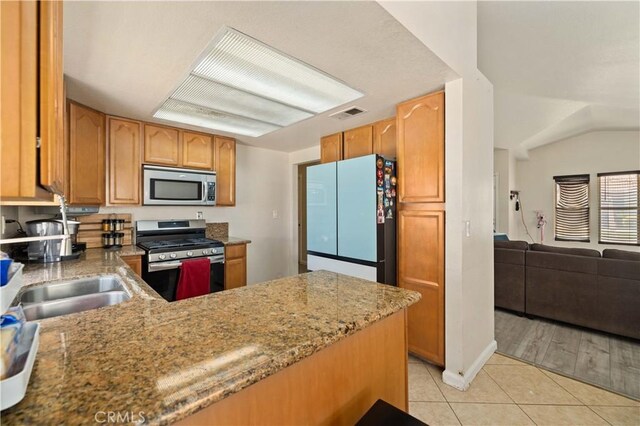kitchen featuring light stone counters, appliances with stainless steel finishes, visible vents, open floor plan, and light tile patterned flooring