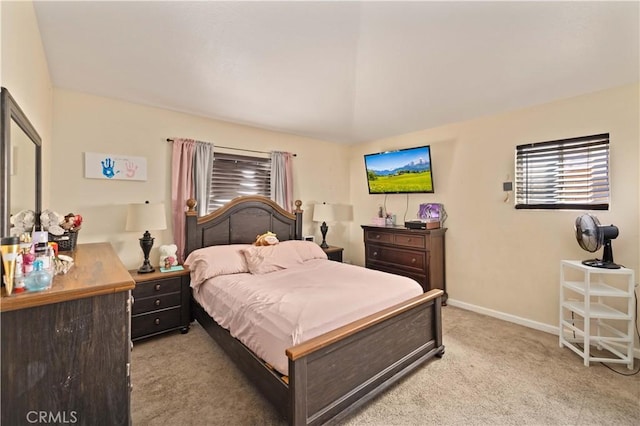 bedroom with light colored carpet and baseboards