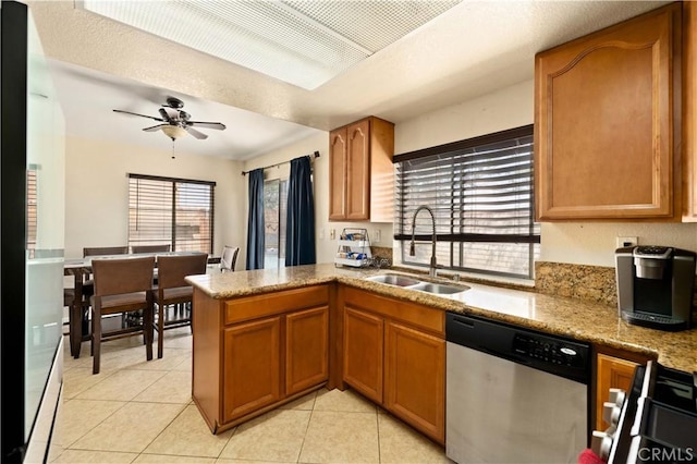 kitchen featuring brown cabinetry, stainless steel appliances, ceiling fan, a sink, and light tile patterned flooring