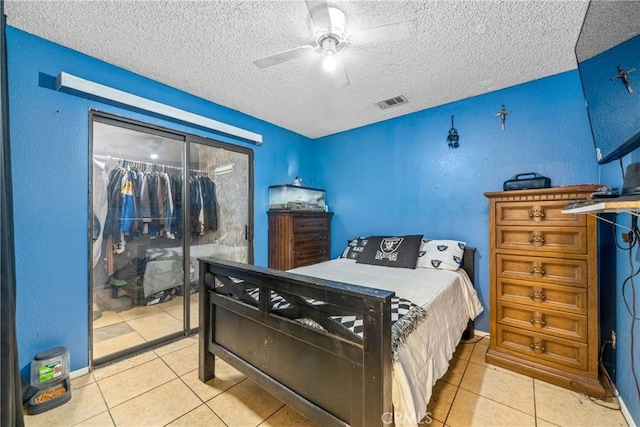 bedroom with light tile patterned floors, ceiling fan, a textured ceiling, and visible vents