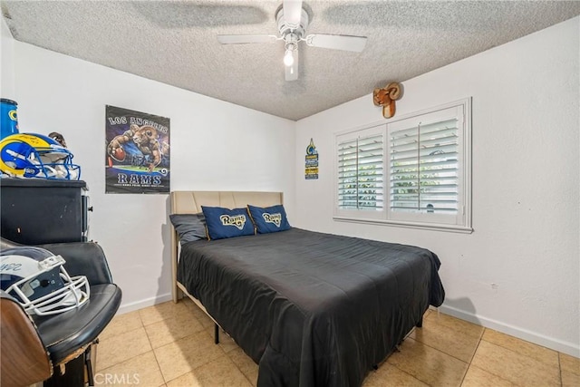tiled bedroom with baseboards, a ceiling fan, and a textured ceiling