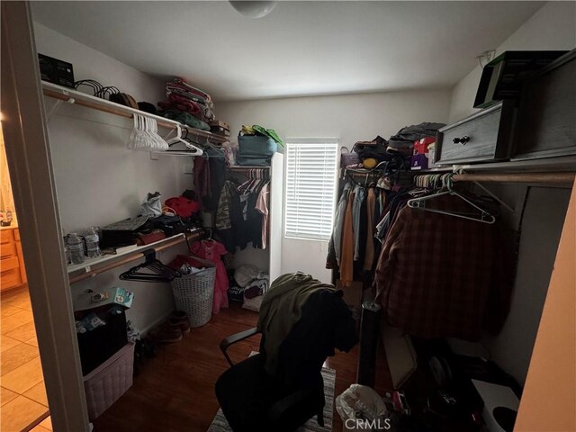 walk in closet with wood finished floors