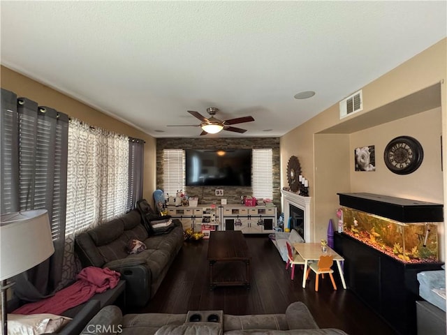 living area featuring wood finished floors, visible vents, and ceiling fan