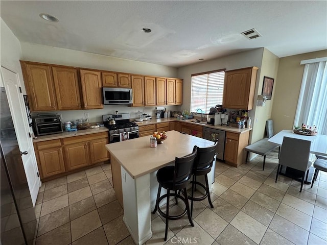 kitchen featuring light countertops, visible vents, stainless steel appliances, and plenty of natural light