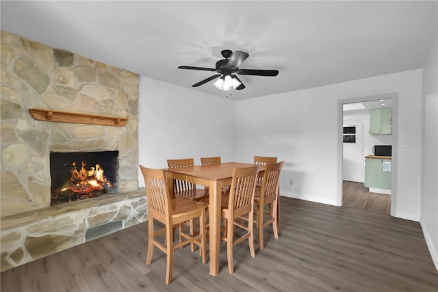 649 Sycamore Ave, Claremont, CA 91711 - dining space featuring wood finished floors, a stone fireplace, a ceiling fan, and baseboards