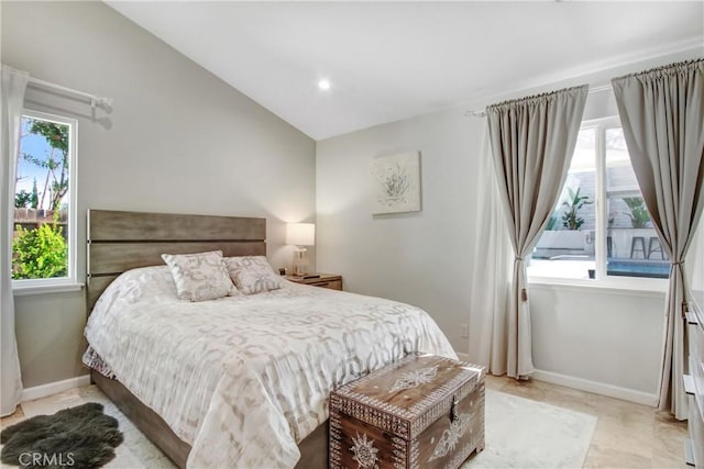 bedroom featuring baseboards, vaulted ceiling, and multiple windows