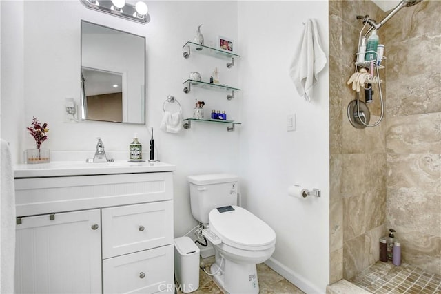 full bath featuring vanity, baseboards, toilet, and tiled shower