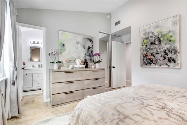 bedroom featuring a closet, high vaulted ceiling, visible vents, and ensuite bath