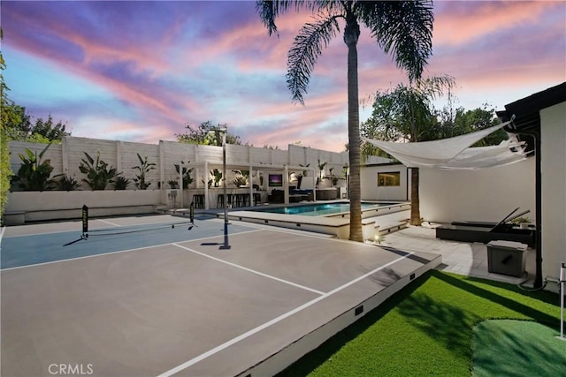 view of sport court featuring an outdoor pool and fence