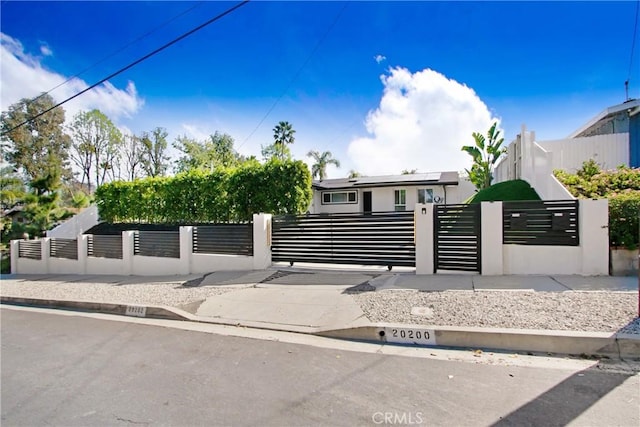 20200 Clark St, Woodland Hills, CA 91367 - view of front facade featuring a fenced front yard, stucco siding, solar panels, and a gate