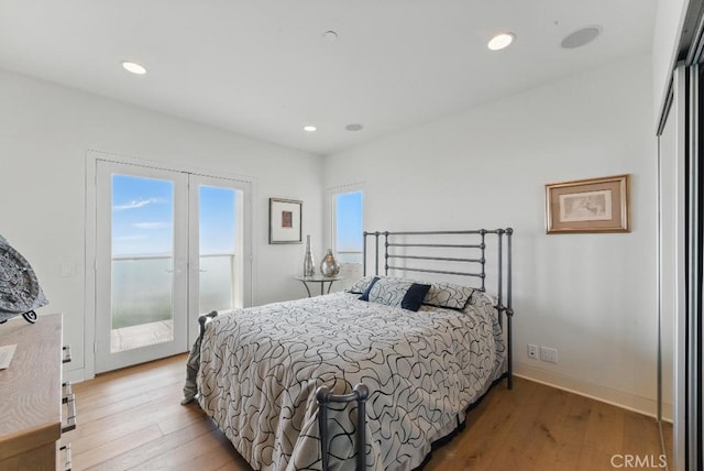 bedroom with wood finished floors, recessed lighting, and access to outside