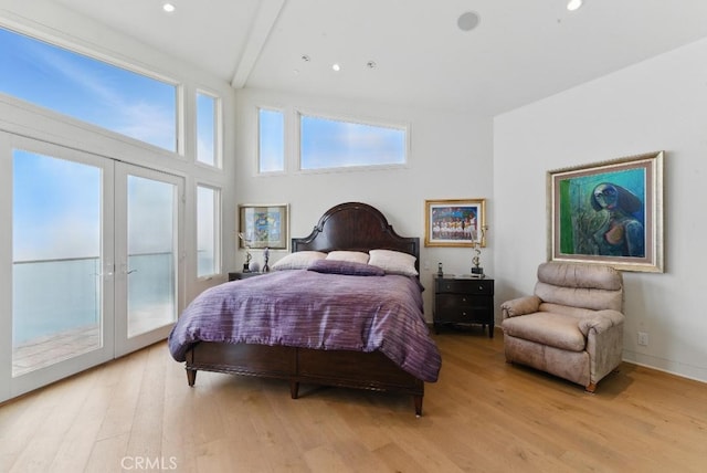 bedroom with recessed lighting, access to exterior, beam ceiling, light wood-type flooring, and french doors