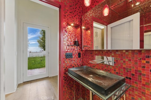 bathroom with backsplash and wood finished floors
