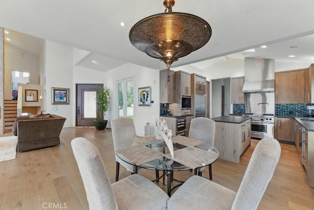 dining area with recessed lighting, light wood-style floors, and lofted ceiling