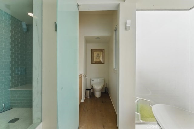 full bathroom featuring toilet, wood finished floors, and a shower stall