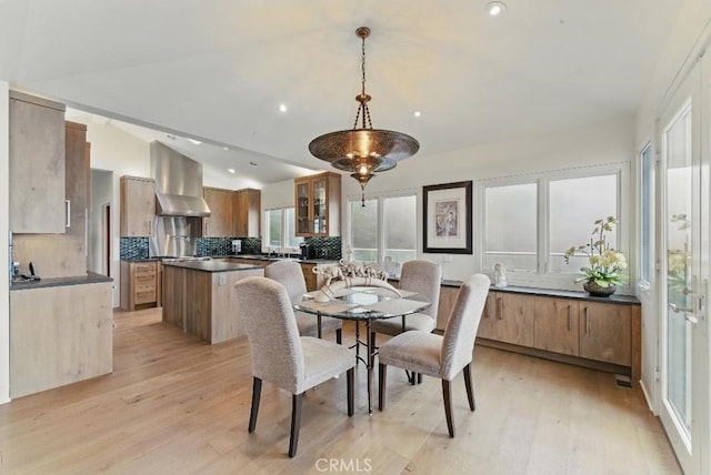 dining area featuring recessed lighting, a healthy amount of sunlight, light wood finished floors, and vaulted ceiling