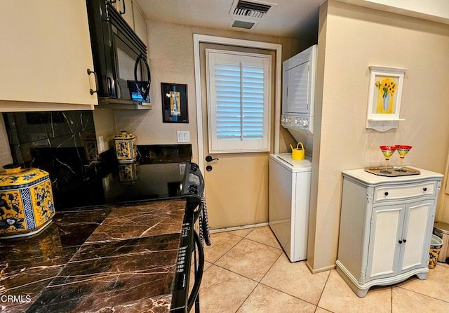 48940 Phlox Pl, Palm Desert, CA 92260 - washroom featuring stacked washing maching and dryer, light tile patterned floors, laundry area, and visible vents