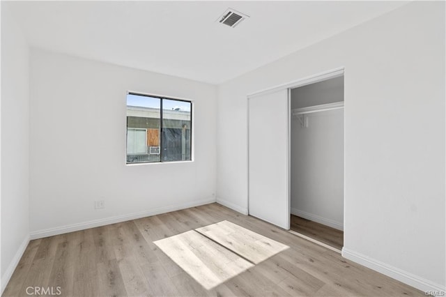 2214 W Wardlow Rd, Long Beach, CA 90810 - unfurnished bedroom with baseboards, visible vents, wood finished floors, and a closet