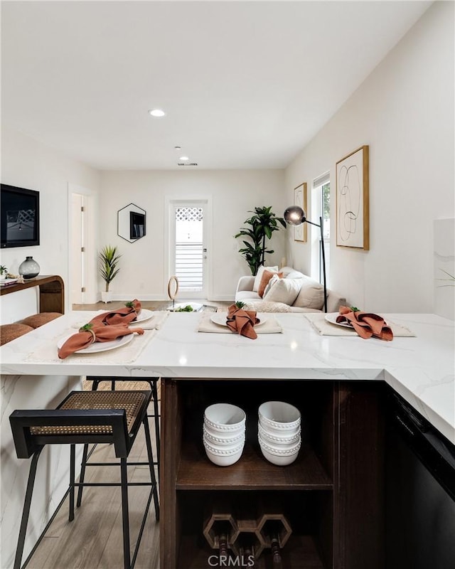 724 San Miguel Ave, Venice, CA 90291 - kitchen with light stone countertops, wood finished floors, dishwasher, open floor plan, and a kitchen breakfast bar