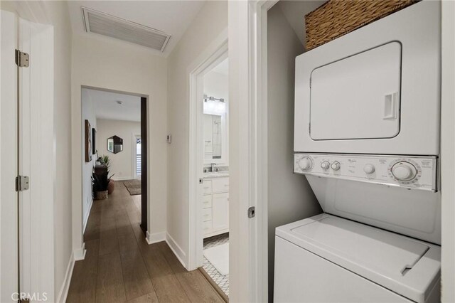 724 San Miguel Ave, Venice, CA 90291 - clothes washing area with wood finished floors, stacked washer and clothes dryer, visible vents, and baseboards