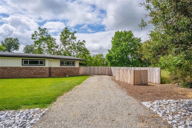 8051 Los Altos Dr, Los Molinos, CA 96055 - exterior space featuring gravel driveway, a yard, fence, and brick siding