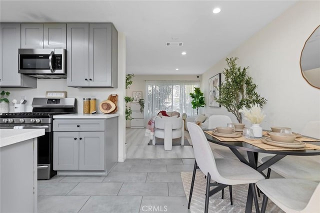 8482 Benjamin Dr Unit 10, Huntington Beach, CA 92647 - kitchen with appliances with stainless steel finishes, visible vents, light countertops, recessed lighting, and gray cabinetry