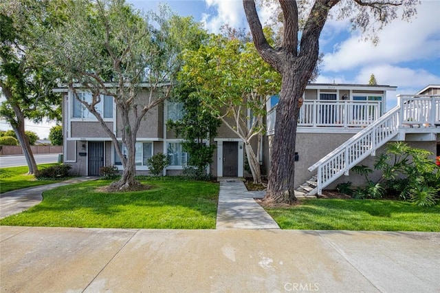 8482 Benjamin Dr Unit 10, Huntington Beach, CA 92647 - view of property featuring a front lawn, stucco siding, and stairway