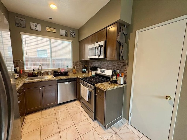 39557 Warbler Dr, Temecula, CA 92591 - kitchen with appliances with stainless steel finishes, a sink, decorative backsplash, light stone counters, and dark brown cabinetry