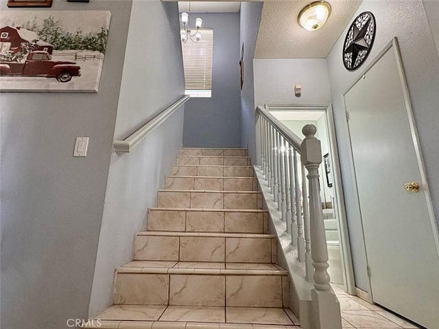39557 Warbler Dr, Temecula, CA 92591 - stairs featuring a chandelier, marble finish flooring, and a textured ceiling