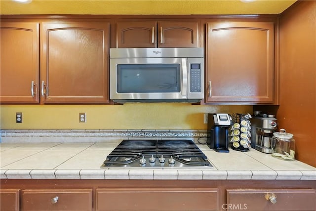 kitchen with brown cabinets and appliances with stainless steel finishes