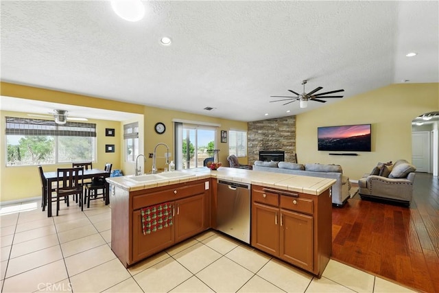 kitchen with open floor plan, ceiling fan, dishwasher, and a sink