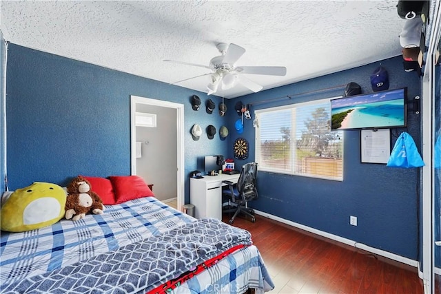 bedroom with a textured ceiling, wood finished floors, and a textured wall