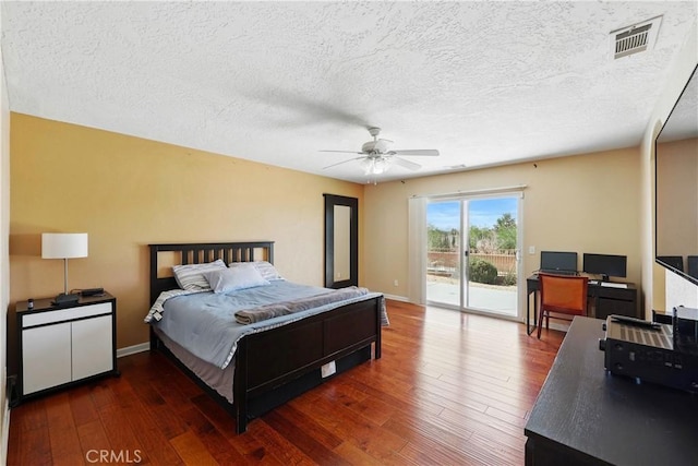 bedroom with a textured ceiling, visible vents, hardwood / wood-style flooring, and access to exterior