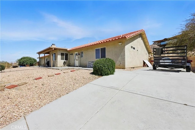 view of front of house with stucco siding and a patio area