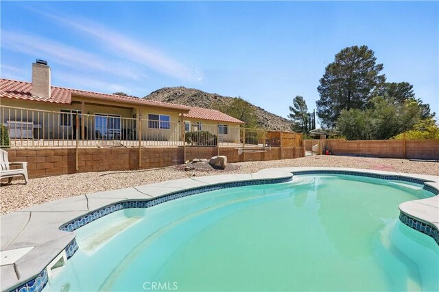 view of swimming pool with a mountain view, a fenced in pool, and a fenced backyard