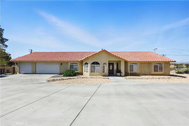 15710 Rimrock Rd, Apple Valley, CA 92307 - mediterranean / spanish home featuring a tiled roof, an attached garage, driveway, and stucco siding