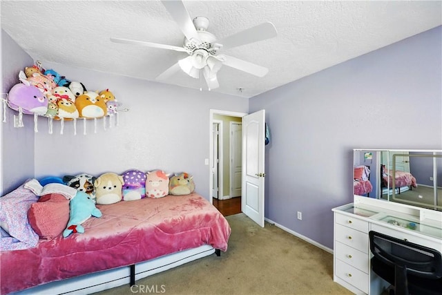 carpeted bedroom featuring a textured ceiling, ceiling fan, and baseboards