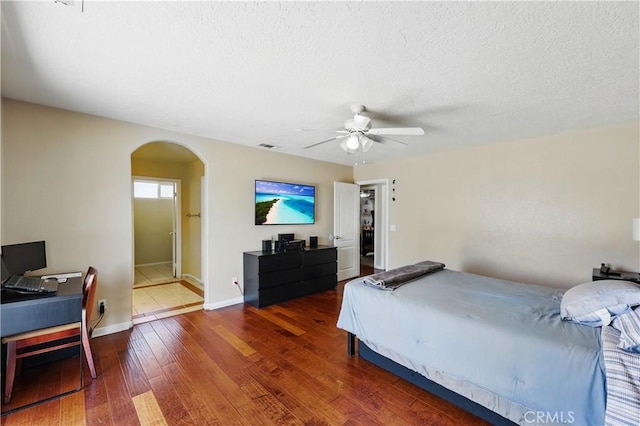 15710 Rimrock Rd, Apple Valley, CA 92307 - bedroom featuring wood finished floors, baseboards, ceiling fan, a textured ceiling, and arched walkways